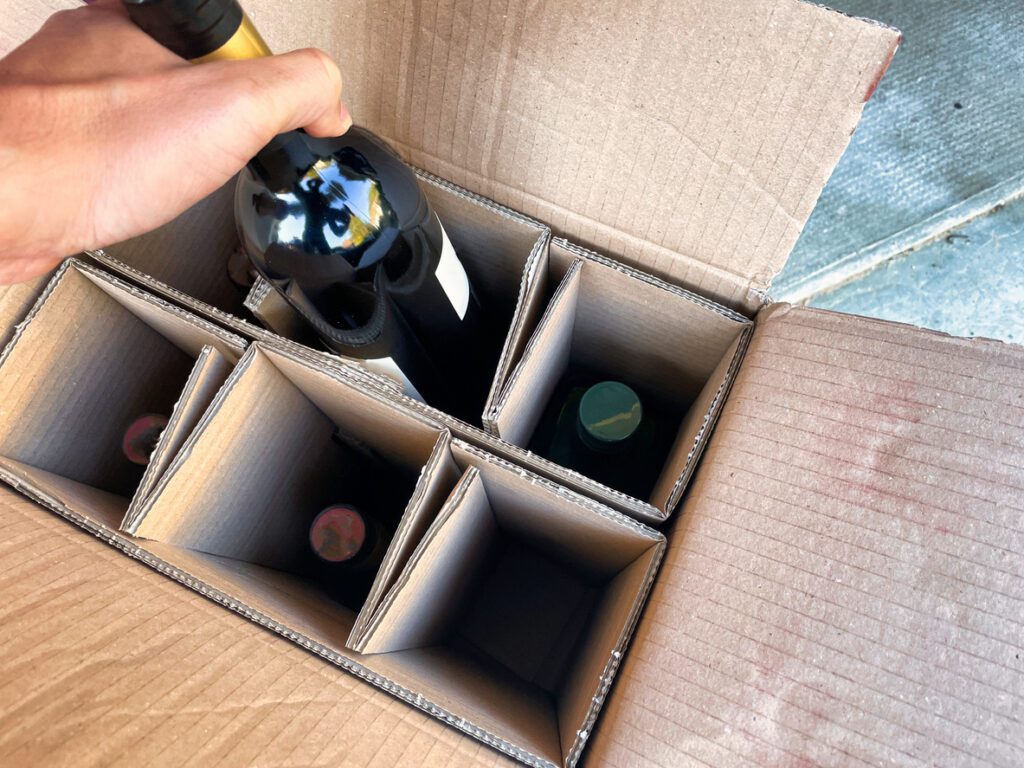 Customer opens a wine delivery box, ordered through wine subscription software.