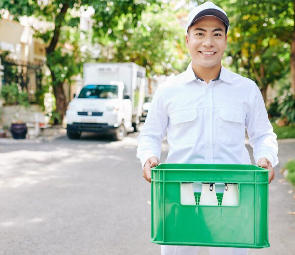 Man delivers fresh milk using delivery solutions designed for local dairies.