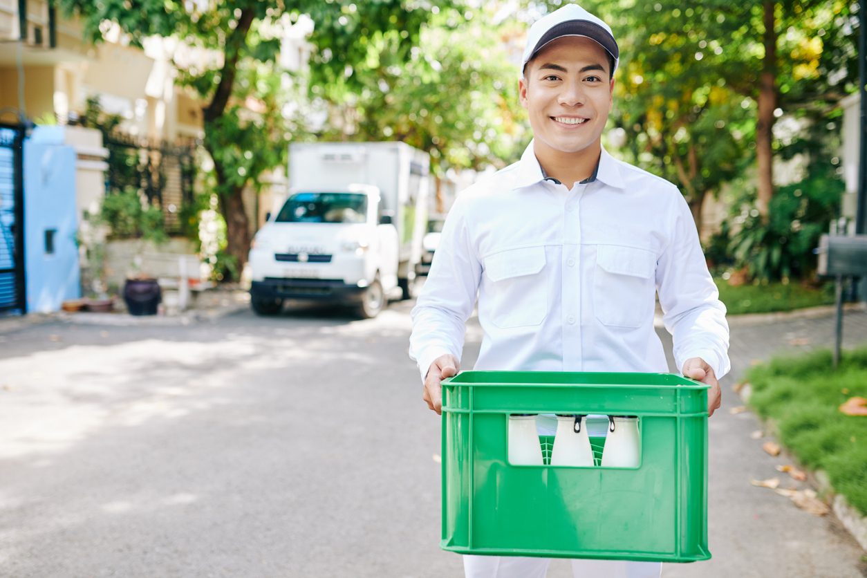 Man delivers fresh milk using delivery solutions designed for local dairies.