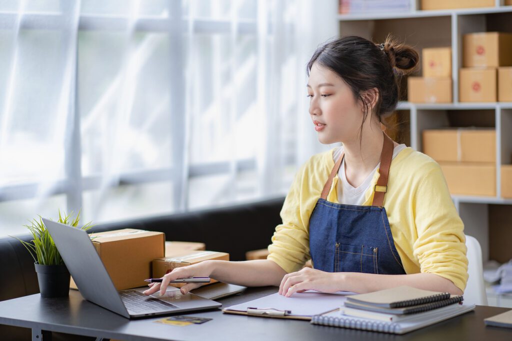 A business owner uses payment processing software on her laptop to manage subscription payments.