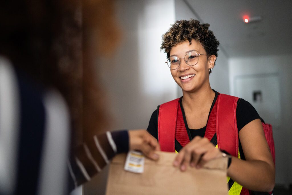 Deliver person delivers food after using software to streamline her routing and payment processing.