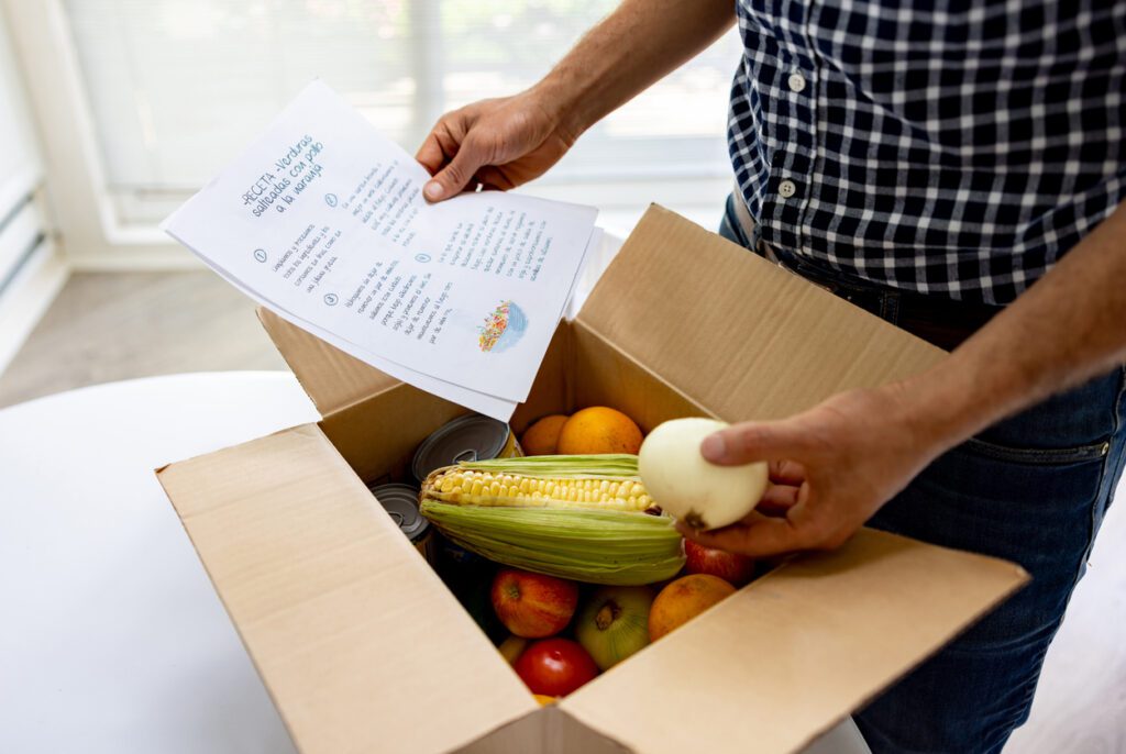 A man checking out a box full of farm produce.