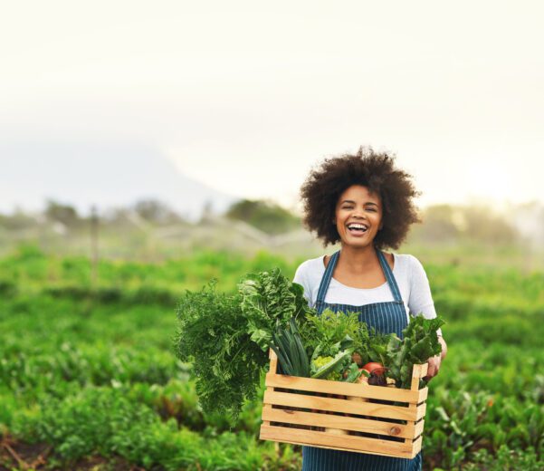 A young woman holding farm produce.