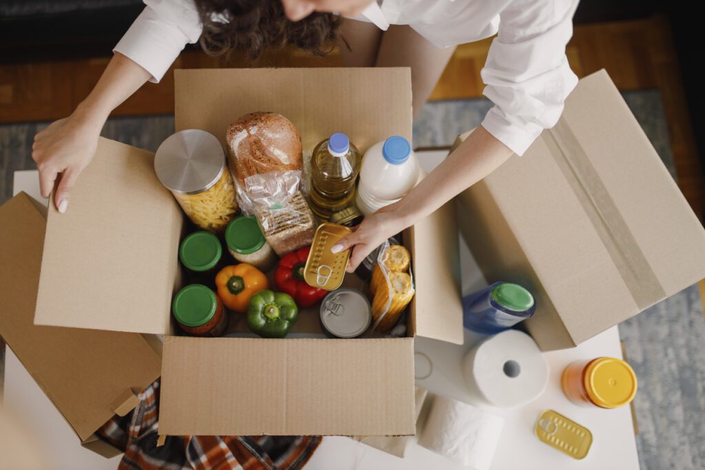 Customer unpacks delivery box from a local farm, which uses technology to implement sustainable farming practices and meet customer delivery needs. 